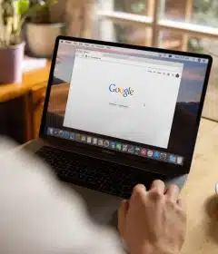 person using macbook pro on table